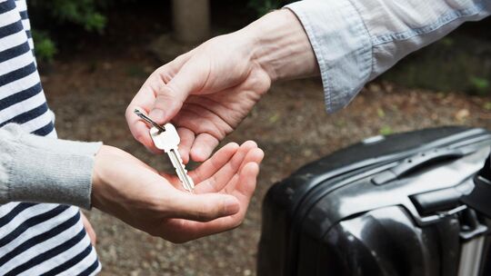 Ein Vermieter übergibt dem Feriengast einen Schlüssel. Symbolfoto: Stock Adobe Ein Vermieter übergibt dem Feriengast einen Schlüssel. Symbolfoto: Stock Adobe